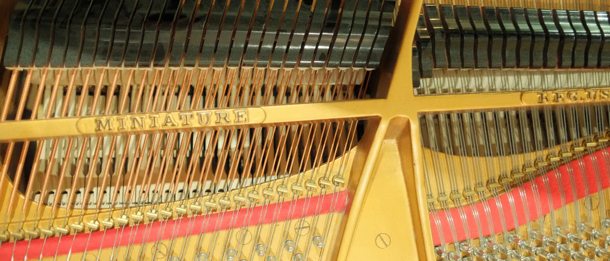 The full harp of the grand: strings crossing the gold frame
