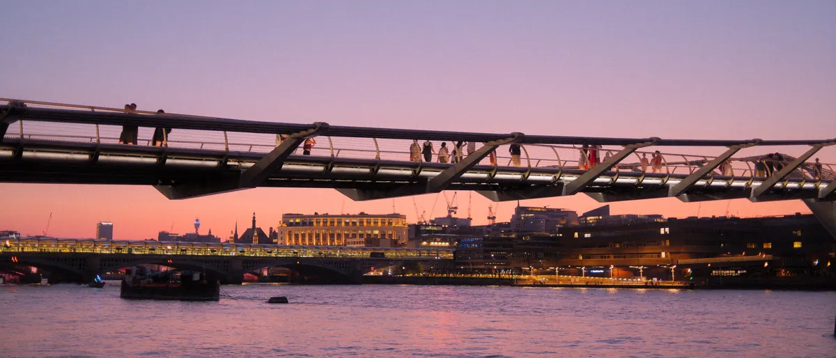 London at dusk: a footbridge over the river, people crossing