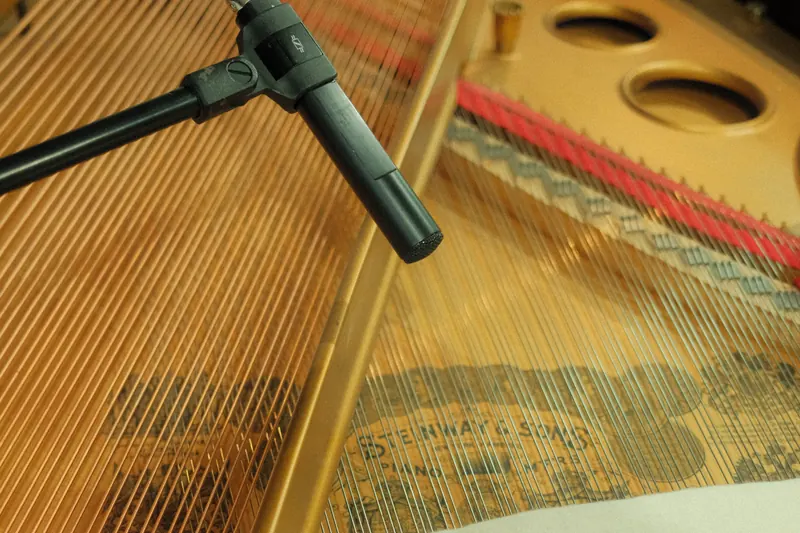 A microphone hanging over the strings, inside the piano